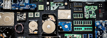 Assorted computer components including hard disk drives, cables, CPUs, and RAM modules.