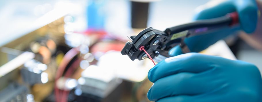 Worker assembling electronics in electronics factory, focus on hands